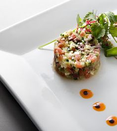 a white plate topped with food and garnishes on top of each other