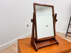 a mirror sitting on top of a wooden table