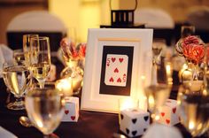 the table is set with candles, cards and wine glasses for an elegant casino party