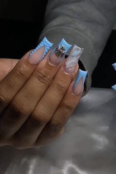 a woman's hands with blue and white nail polish holding a ring on her finger