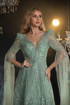 Treten Sie in Eleganz ein mit diesem mintgrünen Abendkleid mit Pailletten, das Sie bei jedem Anlass zum Strahlen bringt. Das Kleid verfügt über ein faszinierendes Paillettenmuster, das das Licht wunderschön einfängt und ein bezauberndes Funkeln erzeugt. Der tiefe V-Ausschnitt ergänzt das taillierte Oberteil, während die transparenten, verzierten Cape-Ärmel anmutig von den Schultern herabfließen und einen Hauch ätherischen Charmes verleihen.

 Das Kleid geht in einen fließenden A-Linien-Rock übe Evening Gown Plus Size, Green Gowns, Dress With Cape Sleeves, Simple Satin Wedding Dress, Fashion Dresses For Women, Nontraditional Wedding Dress, Antoinette Dress, Wedding Dresses High Low, Champagne Evening Dress