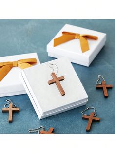 three wooden crosses sitting on top of a table next to a box with a bow