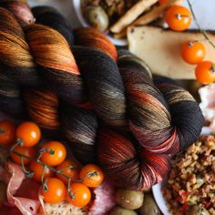 several skeins of yarn, tomatoes and other food items