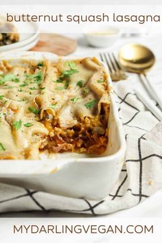 a white casserole dish filled with meat and cheese, topped with parsley