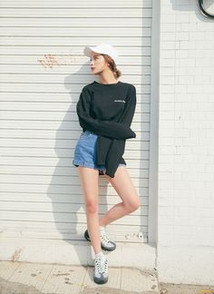 a young woman is leaning against a wall