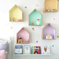 the wall is decorated with little houses and books on it's shelves for children to read