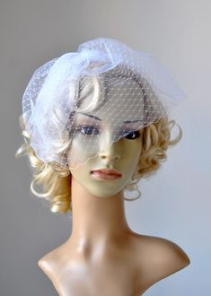 a mannequin head wearing a white veiled hat