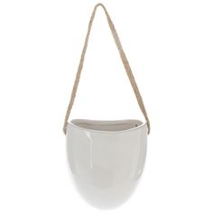 a white pot hanging from a rope on a white wall with no one in it