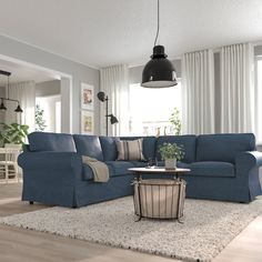 a living room with blue couches and white rugs on top of a wooden floor