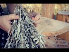 a person is holding some dried herbs in their hands while they are making something out of wood