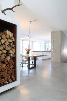 there is a large pile of firewood in the middle of this living room and dining area