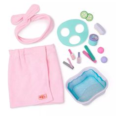 a doll's accessories are laid out on a white surface, including a pink towel, scissors, combs and toothbrushes