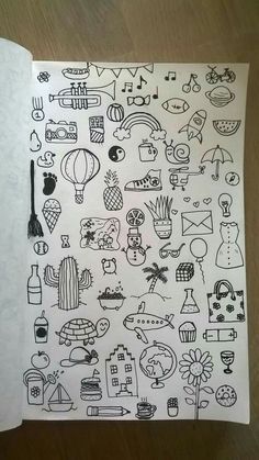 an open notebook with doodles on it and various things drawn in the book's pages