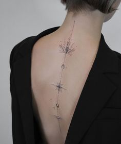 the back of a woman's neck is shown with flowers and stars on it