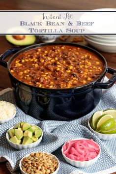 several bowls of food on a table with one bowl full of chili and the other two bowls filled with guacamole