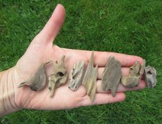 a person's hand holding five small animal figurines