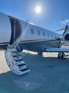 an airplane sitting on the tarmac with steps leading up to it's door