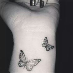 two small butterflies on the wrist tattoo design for women, one in black and white