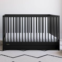 a black crib with white sheets in a room