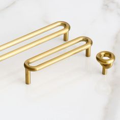 two brass handles on a marble counter top