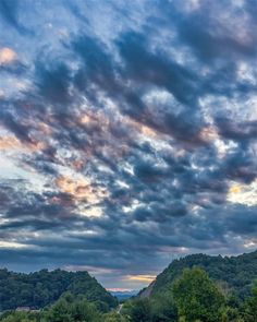 the sky is full of clouds and trees