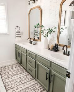 a bathroom with black and white tiles on the floor, two sinks and a large mirror