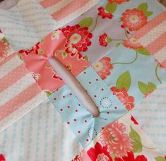 a patchwork table cloth with flowers and polka dots on the edges, along with a knife