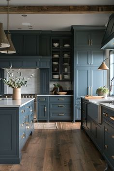 a large kitchen with blue cabinets and wooden floors is pictured in this image from the front view