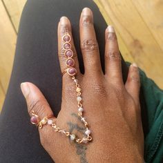 a woman's hand with gold rings and bracelets