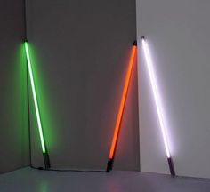 two different colored lightsticks sitting next to each other on a white surface in front of a wall