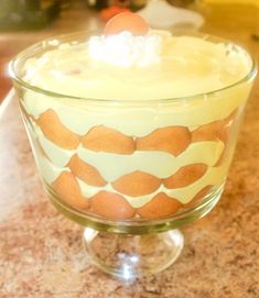 a glass bowl filled with pudding on top of a counter next to a banana peel