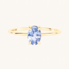 a yellow gold ring with an oval blue topazte