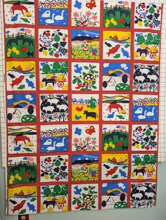 a quilt made to look like an animal theme is hanging on a wall in a room