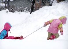 two young children playing in the snow