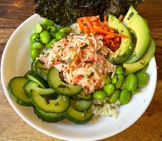 a white plate topped with lots of veggies next to broccoli and carrots