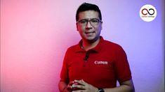 a man standing in front of a pink and purple wall with the canon logo on it