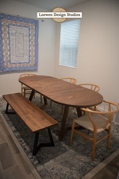 a wooden table with two chairs and a bench in front of a window on a rug