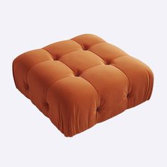 an orange square footstool on a white background