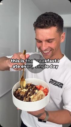 a man holding a bowl of cereal and spoon