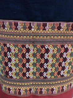 a close up of a person wearing a skirt with different colored designs on the side