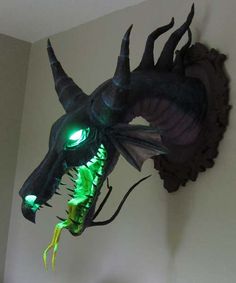 a green dragon head mounted to the side of a wall