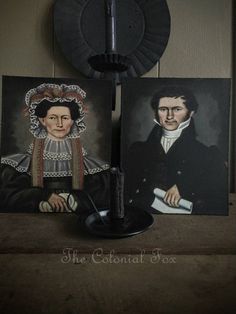 two paintings of people are on display in front of a lamp and some other items