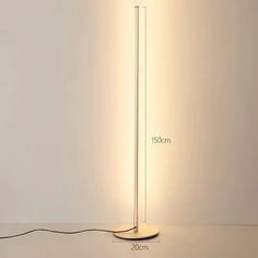 a floor lamp with a white base and a light bulb on the end that is plugged in