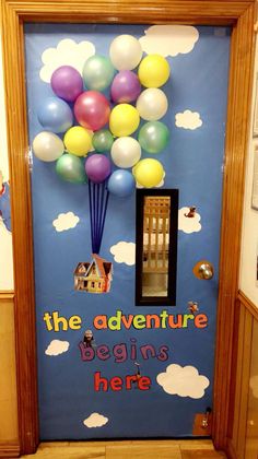 a door decorated with balloons and the words, the adventure begins here on it's side