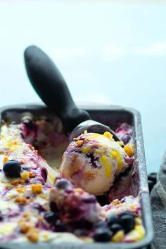 an ice cream sundae with blueberries, oranges and other toppings in a metal pan