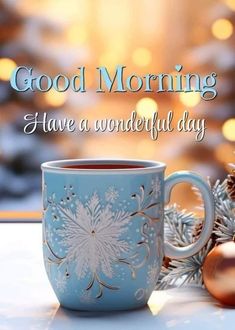 a blue coffee cup sitting on top of a table next to christmas ornaments and decorations