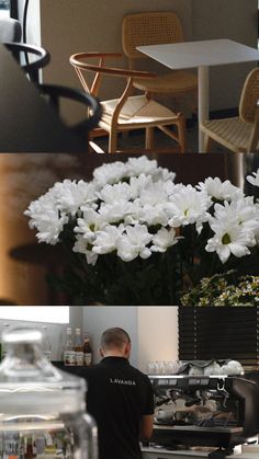 there is a man that is working in the kitchen and flowers are on the counter