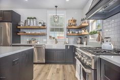 a kitchen with open shelving and stainless steel stove top ovens, shelves on the wall