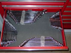 a red tool box filled with lots of wrenches and other metal tools in it