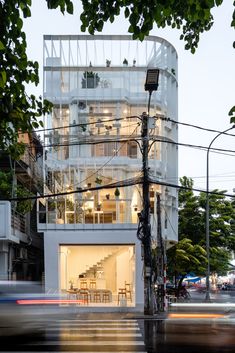 an apartment building that is next to a street with cars passing by on the road